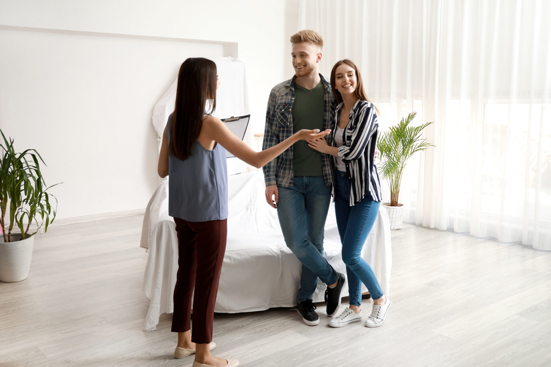 Real Estate Agent Showing Young Couple A New House